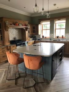 a kitchen with a large island with two bar stools at Country house in Killyhevlin