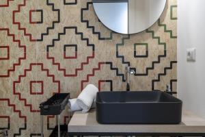 a bathroom with a sink and a patterned wall at La Casa di Laura in Putignano