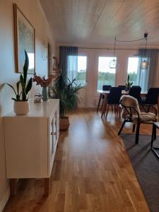 a living room with a white cabinet and a dining room at Riverside villa in Borlänge