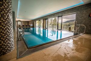 ein Pool mit blauem Wasser in einem Haus in der Unterkunft Wellness Hotel Vista in Dolní Morava