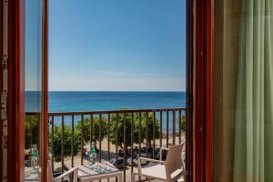 a room with a view of the ocean from a balcony at Hotel El Balear in Alghero