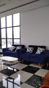 uma sala de estar com dois sofás azuis e uma mesa em Tiga Mahkota homestay em Diyeng