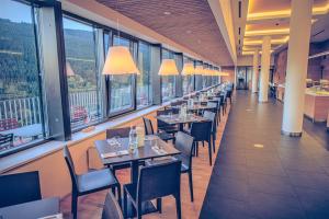 a row of tables and chairs in a restaurant with windows at Wellness Hotel Vista in Dolní Morava