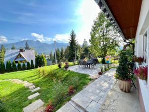 eine Terrasse mit einem Tisch und Stühlen im Hof in der Unterkunft Bystry Domek in Kościelisko