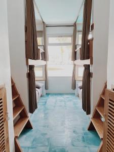 Pokój z niebieską podłogą wyłożoną kafelkami i łóżkami piętrowymi w obiekcie Kos One Hostel w mieście Canggu