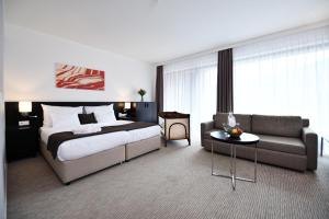 um quarto de hotel com uma cama e um sofá em Wellness Hotel Vista em Dolní Morava