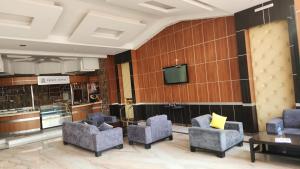 une salle d'attente avec des chaises et une télévision dans l'établissement Al Makan Hotel by Al Azmy, à Riyad