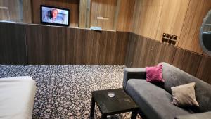 فندق المكان بإدارة العزمي في الرياض: غرفة معيشة مع أريكة وتلفزيون