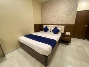 a bedroom with a large bed with blue pillows at Hotel Ashyana-Grant Road Mumbai in Mumbai