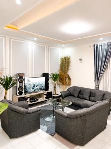 sala de estar con 2 sofás y TV en Villa Sindang Restu Sr 19 Private Pool 4Br 15 Pax, en Cianjur
