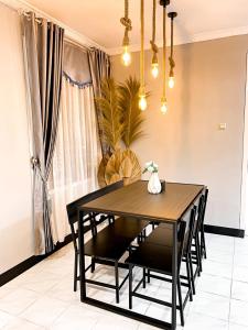 a dining room with a black table and chairs at Villa Sindang Restu Sr 19 Private Pool 4Br 15 Pax in Cianjur