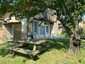 een picknicktafel voor een huis met een boom bij Maison en Drôme des collines 