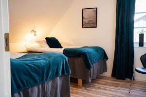 um quarto de hotel com duas camas e uma cadeira em Rymligt radhus med trädgård & parkering em Skurup