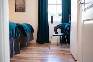 um quarto com 4 camas com cortinas verdes e uma cadeira em Rymligt radhus med trädgård & parkering em Skurup