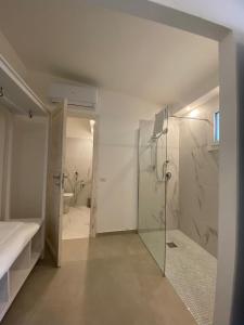 a bathroom with a shower and a glass shower stall at Lido Di Alghero Rooms on the Beach in Alghero