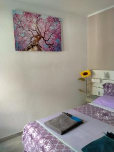 een kamer met 2 bedden en een schilderij aan de muur bij La Casa De MarcoQ in Costa Calma