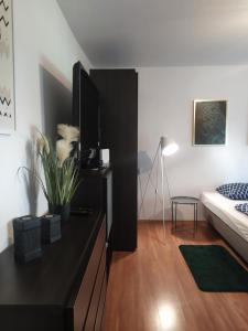 Una sala de estar con una cómoda negra y una cama. en Good Morning Piaskowa Góra, en Wałbrzych