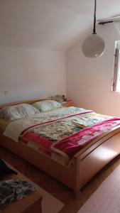 ein Schlafzimmer mit einem Bett mit einer Decke darauf in der Unterkunft Milic apartman in Bar