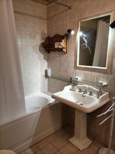 ein Badezimmer mit einem Waschbecken, einer Badewanne und einem Spiegel in der Unterkunft Casa Pisani 21 in Iglesias