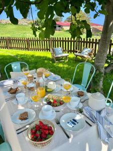 a white table with food and glasses of orange juice at Casa Nueva cerca del Mar en cala Berellin in Prellezo