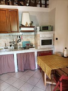 a kitchen with a sink and a stove and a table at Casa Pisani 21 in Iglesias