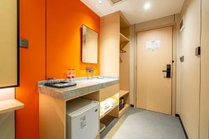 a bathroom with a sink and an orange wall at WAIFIDEN Hotel -Former Tokai Hotel in Guangzhou +34 photos