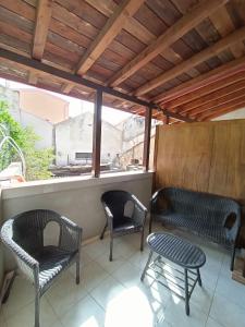 2 sedie e un tavolo su un portico di Casa Pisani 21 a Iglesias