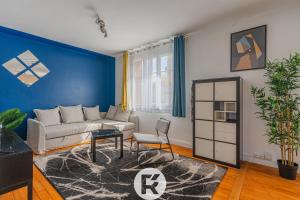 uma sala de estar com um sofá e uma parede azul em R 'Apparts T3 Isère Dreams em Grenoble