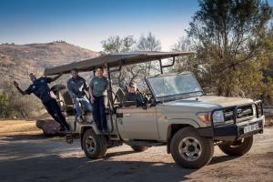 a group of people are standing in a jeep at Riverhorse Lodge in Lanseria