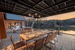 an outdoor dining area with a table and chairs at Riverhorse Lodge in Lanseria +11 photos