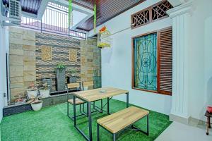 a table and bench in a room with a window at Capital O 92990 Nena Kostel Syariah in Padang