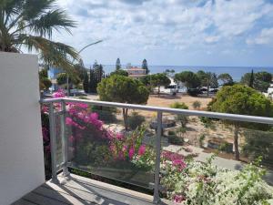 a balcony with a view of the ocean and flowers at Villa Neyla Four bedroom Coral Bay Beach front in Coral Bay