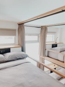 a bedroom with two bunk beds and a window at Kos One Hostel in Canggu