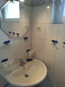 a white bathroom with a sink and a mirror at Ferienreihenhaus Am Knüll, Dahme in Dahme