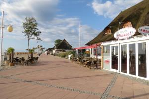 a boardwalk with tables and chairs and a restaurant at Ferienreihenhaus Am Knüll, Dahme in Dahme
