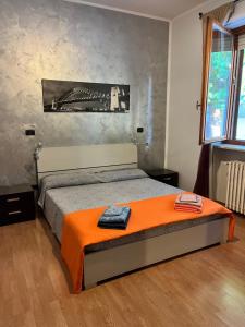 a bedroom with a bed with an orange blanket at Matilda’s Apartment in Strambino