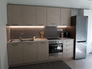 a kitchen with white cabinets and a stainless steel refrigerator at Tsakalof Loft Apartment by SuperHost Hub in Athens