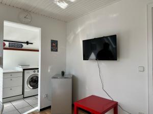 een woonkamer met een tv aan een witte muur bij Spacious & Cozy Apartments in Krefeld