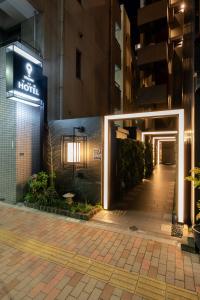 stayme THE HOTEL Ueno في طوكيو: مدخل الفندق مع وجود لافته على جانب المبنى