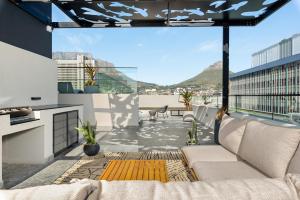 a patio with a couch on a balcony at The Tokyo Aparthotel by Totalstay in Cape Town