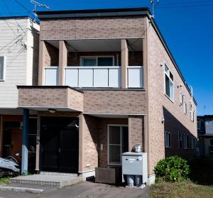 a brick house with a balcony on top of it at Villa Futaba若松町 in Hakodate