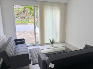 a living room with a couch and a table at Beautifully refurbished 5-bed - Great Transport - Free Parking (sleeps 12) in London