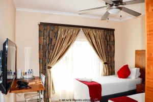 a bedroom with a bed and a window at Meet Mekaar Resorts - Nquthu Hotel in Nqutu