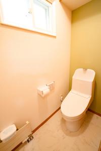 a bathroom with a white toilet and a window at Villa Futaba若松町 in Hakodate
