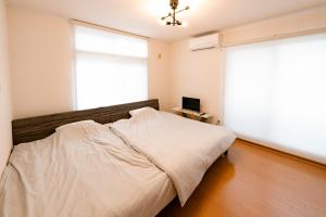 函館市にあるVilla Futaba若松町のベッドルーム1室(ベッド1台、大きな窓付)