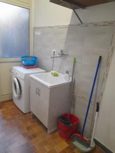 a bathroom with a sink and a washing machine at Casa Vacanza Marano in Mascali +10 photos