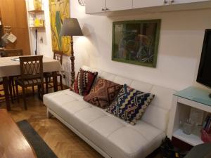 una sala de estar con un sofá blanco con almohadas. en LILIUM HOUSE Apts, en Roma