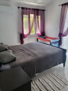 een slaapkamer met een groot bed en roze gordijnen bij Villa Neyla Four bedroom Coral Bay Beach front in Coral Bay