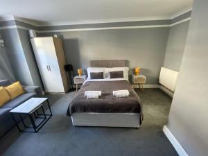 a bedroom with a bed and a couch at Gravesend 1 Bedroom Apartment 2 Min Walk to Station - longer stays available in Gravesend