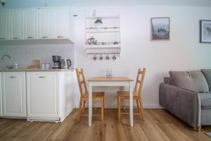 - un salon avec une table, des chaises et un canapé dans l'établissement Apartament przy Zdrojowej, à Ciechocinek